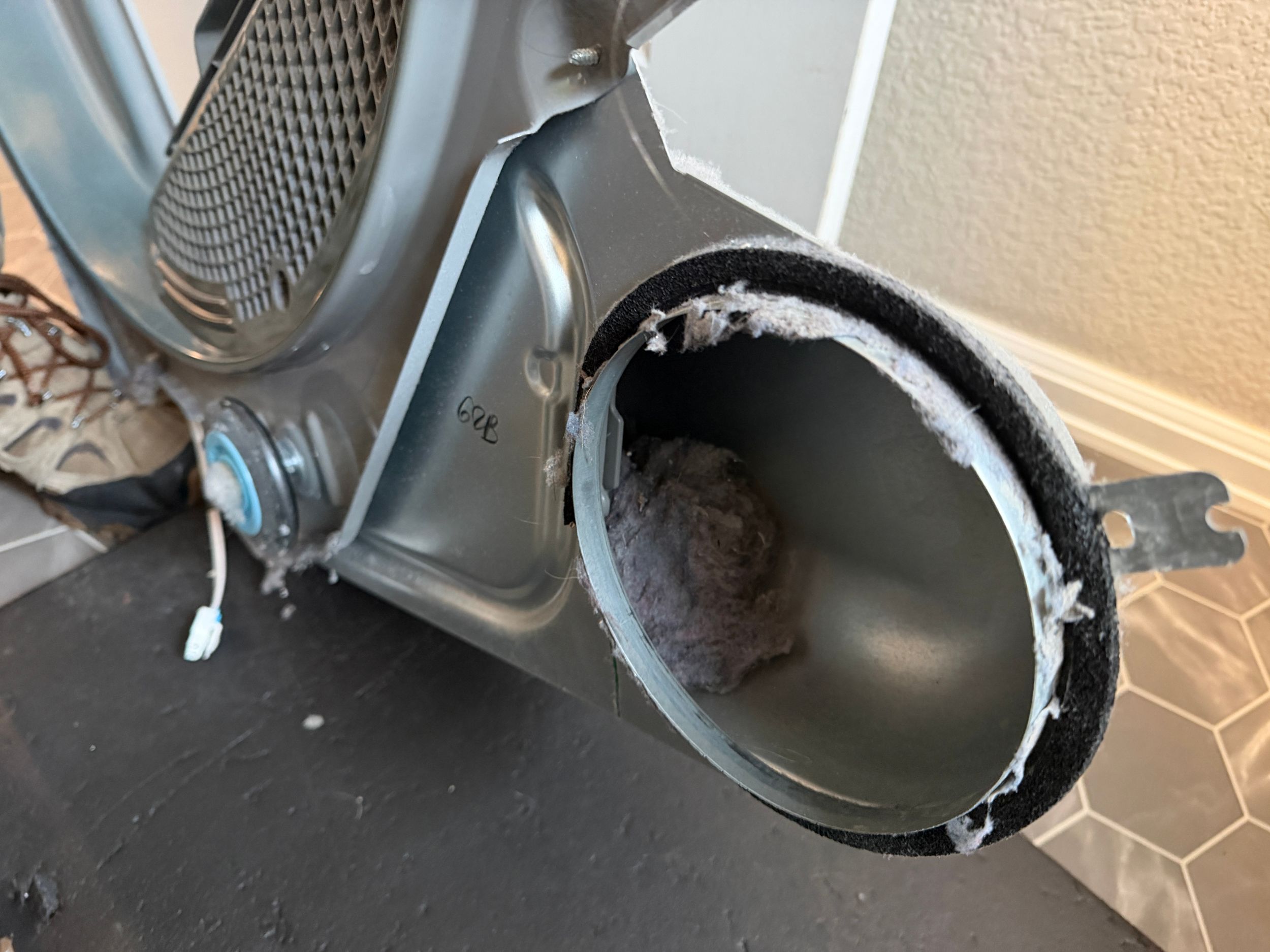 Lint jam inside a dryer lint filter housing. Buildup like this restricts airflow and increases fire risk